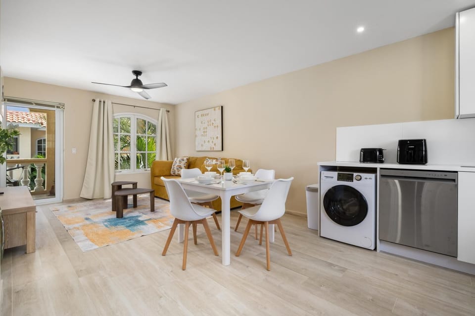 Cook and dine with ease in a fully equipped kitchen complete with modern appliances, cookware, and plenty of storage. The nearby dining table invites you to gather, share meals, and enjoy each moment together.