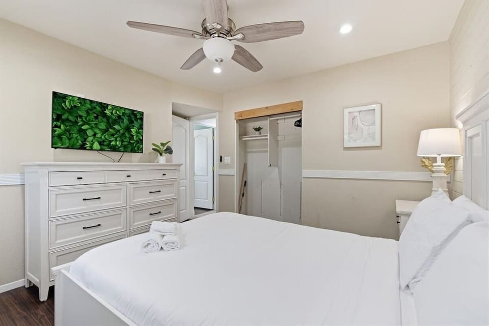 4th Bedroom featuring a Queen bed with a smart TV, dresser, and closet.