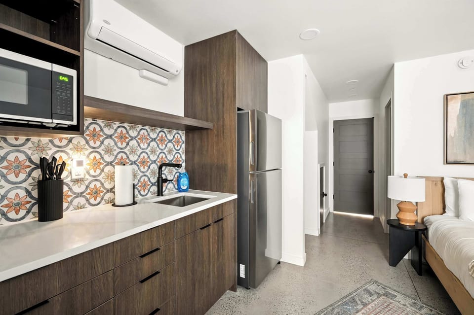 Kitchen with microwave and stainless refrigerator.