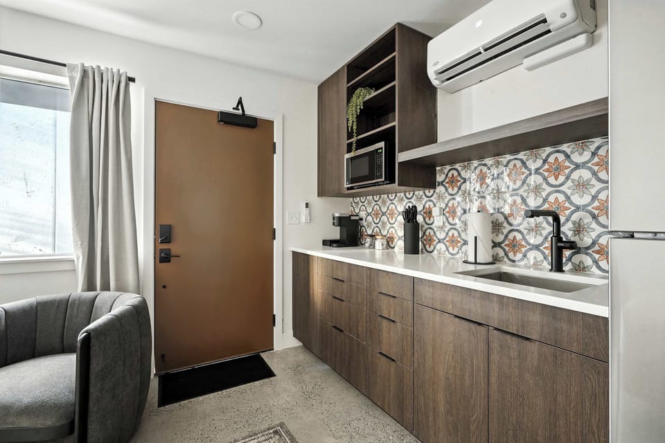 Kitchen counter with patterned tile and front entry.
