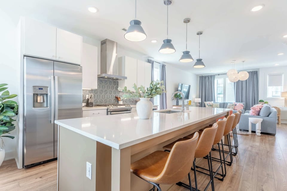 Discover your dream vacation home in Downtown Nashville! This modern kitchen boasts elegant decor and ample space for gatherings. Enjoy brunch at the stylish island or whip up a gourmet dinner before a night out. Your Nashville adventure awaits!