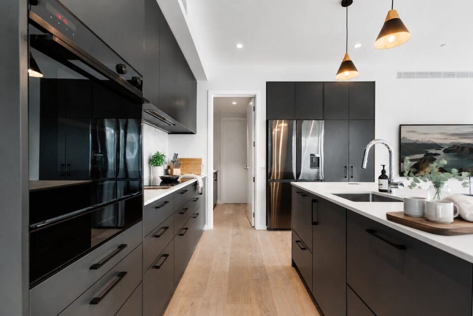 Fully kitted out with premium appliances, deep storage, and moody dark cabinetry - serious enough for a dinner party, easy enough for every day.