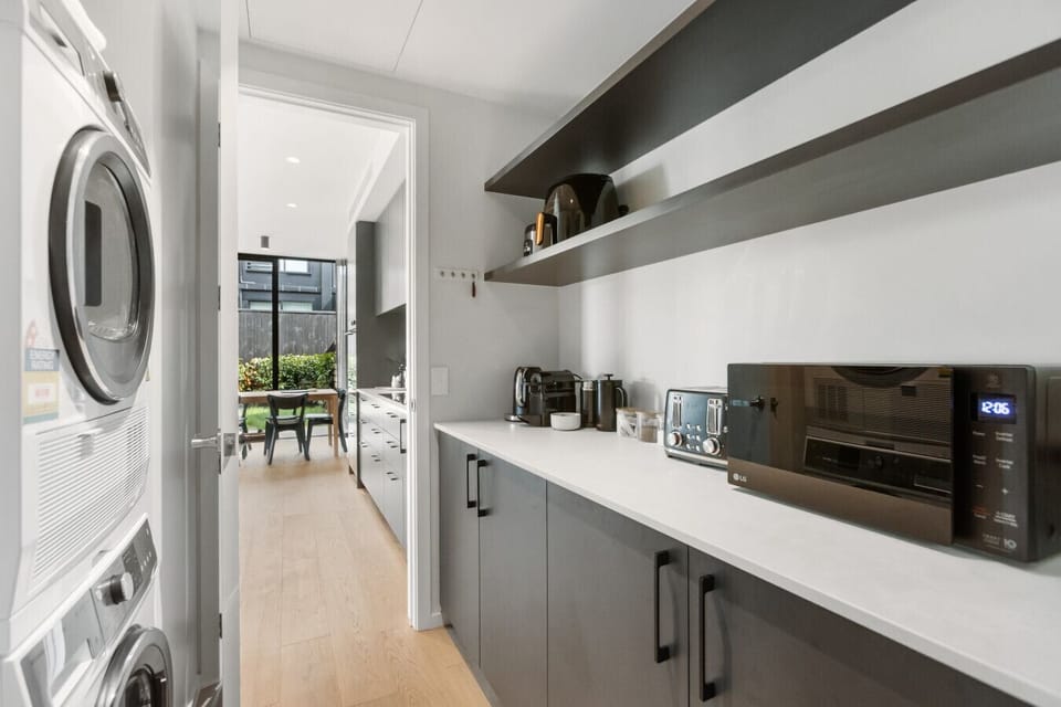 Full laundry with washer, dryer, and extra bench space - everything you need for a longer stay, neatly tucked away.