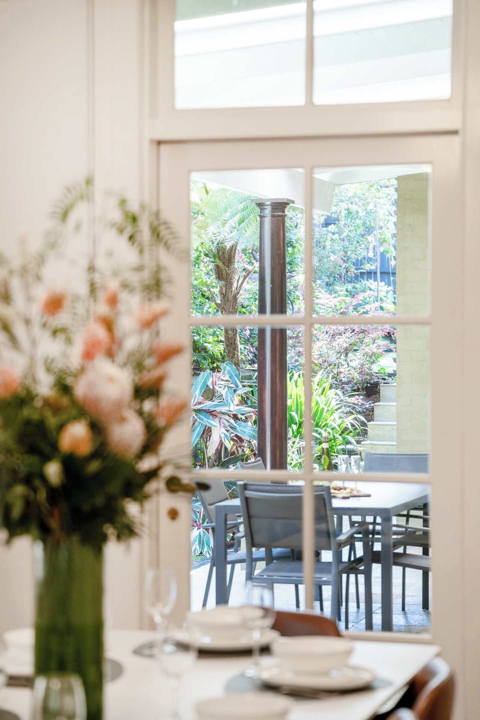 The elegant dining area seamlessly connects to the lounge, creating a spacious and welcoming flow. A charming doorway opens out to the alfresco space, perfect for enjoying morning coffee or evening meals in the fresh air.