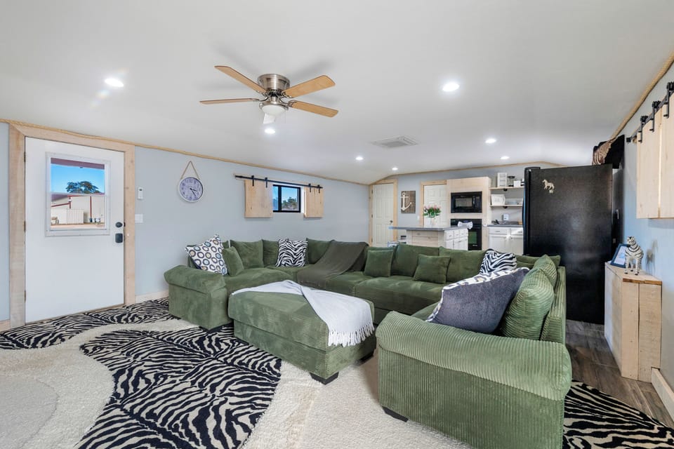 Zebra Ranch living room 2 with natural wood finishes, a large TV, and comfortable seating, ideal for kicking back after a day on the ranch.