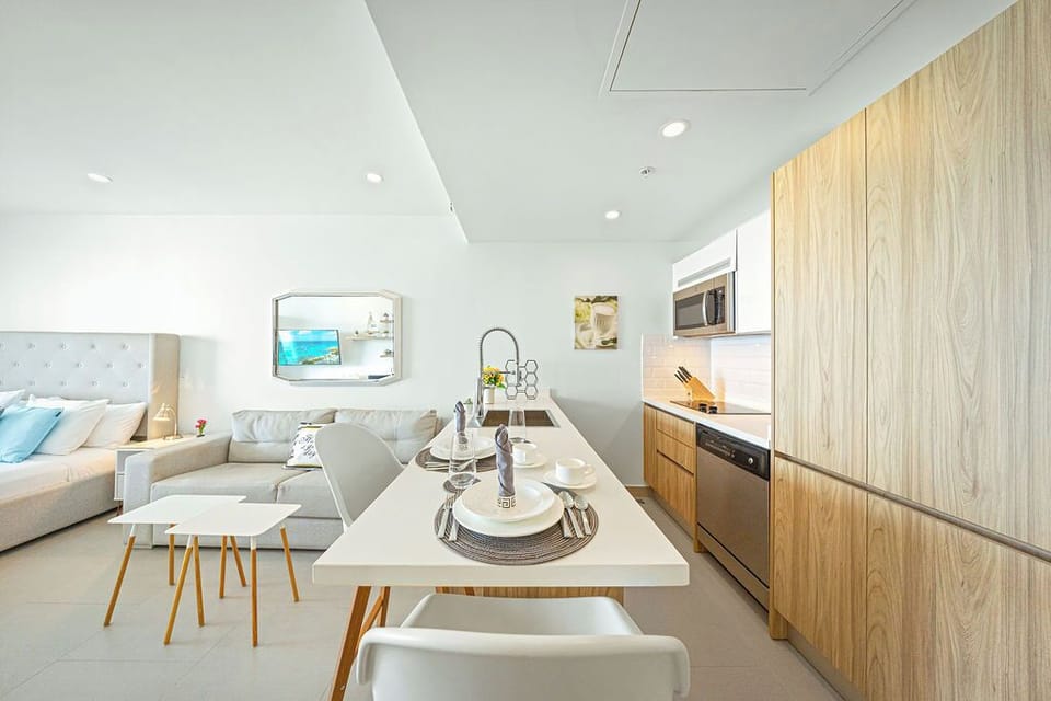 Settle into your bright, open studio space where sleek design meets comfort—your cozy bed, soft sofa, and modern kitchen blend seamlessly for easy living.