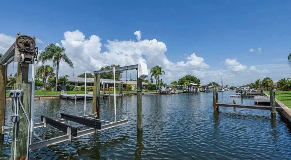 Waterfront backyard with lush green lawn and serene canal views. Perfect for morning coffee, sunset relaxation, or fishing. 