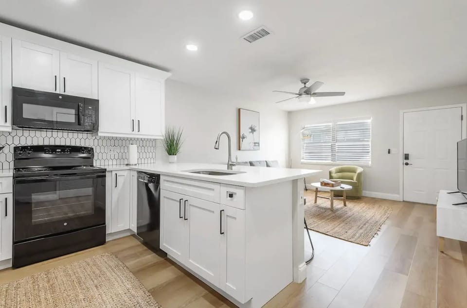 Bright open kitchen with modern appliances, sleek countertops, and cozy living area views. Perfect for cooking, dining, and relaxing in a stylish, welcoming space filled with natural light.