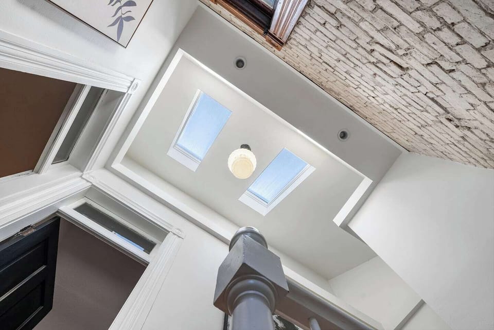 Natural light spills into the second floor hallway and staircase through the skylights above