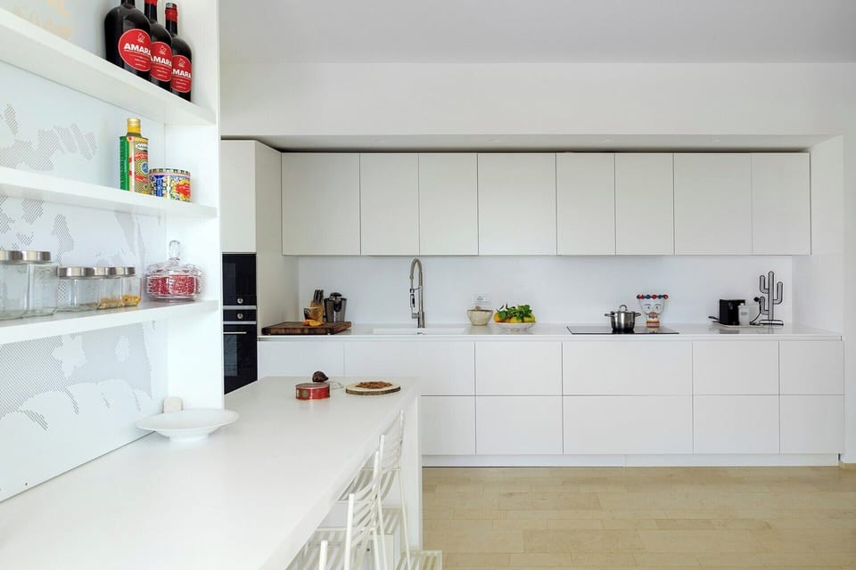 The sleek white design of the kitchen.