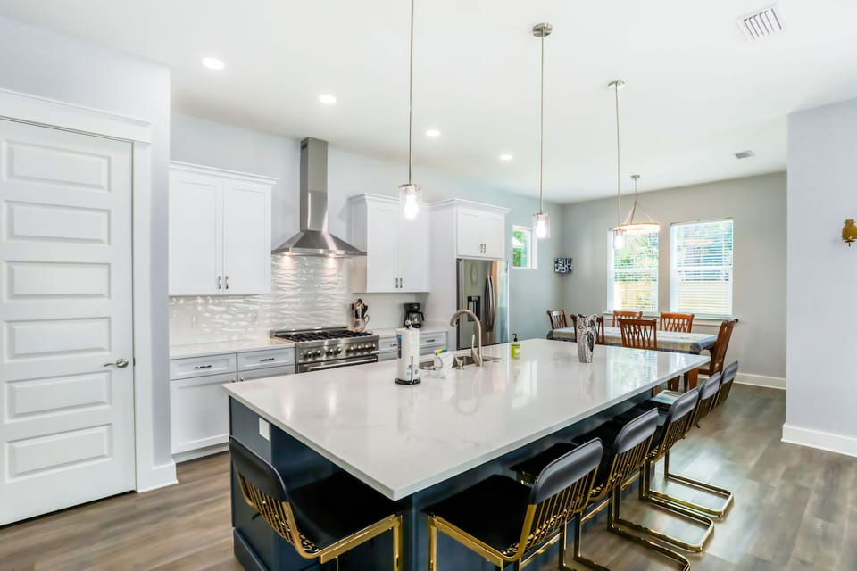 The kitchen features crisp white cabinetry and bright accents.