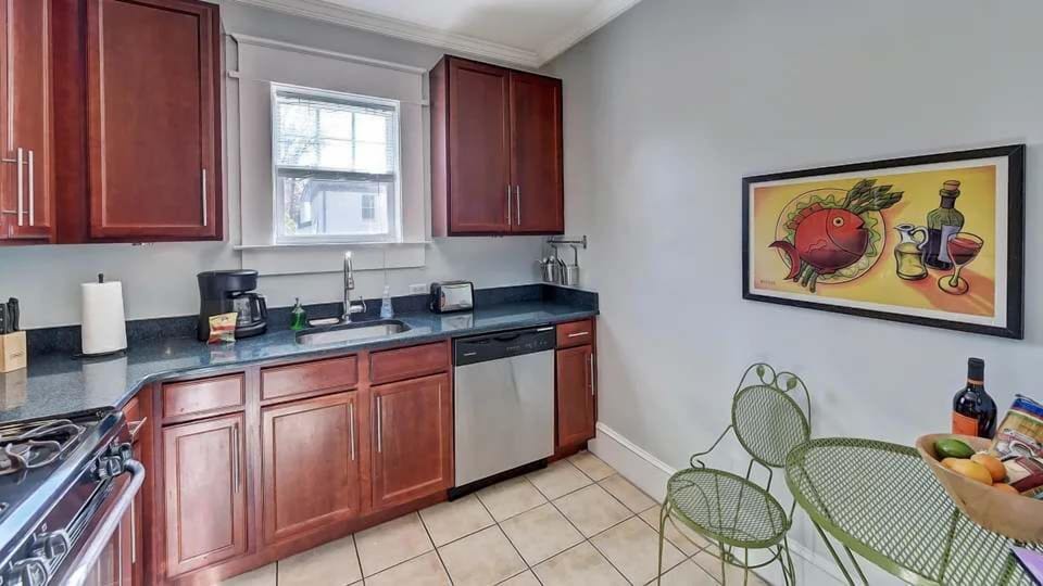 This bright kitchen features modern appliances, ample counter space, and a cozy dining nook for casual meals. Natural light from the window creates a warm and inviting space to cook and gather.