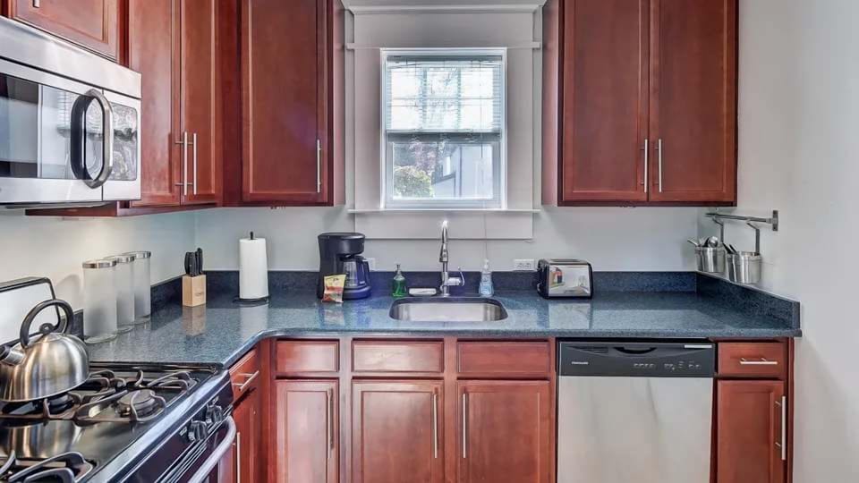 This bright kitchen offers modern appliances, ample counter space, and a clean, functional layout. A window above the sink brings in natural light, making it a pleasant space to cook and prepare meals.