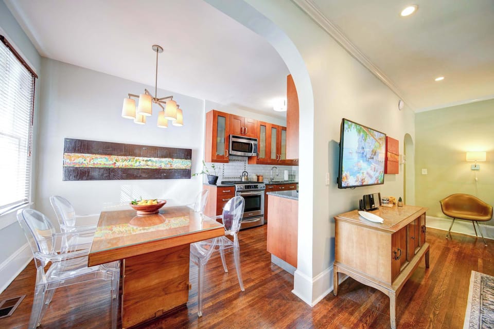Open dining area in Charlotte featuring a modern table, pendant lighting, and seamless flow into the fully equipped kitchen. Bright, functional space ideal for meals, remote work, or gathering during your stay in the city.