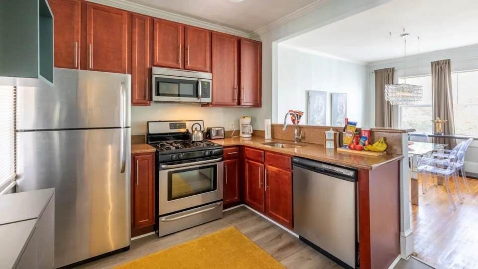 This modern kitchen features stainless steel appliances, ample counter space, and an open layout that flows into the dining area. A bright and functional space perfect for everyday cooking.