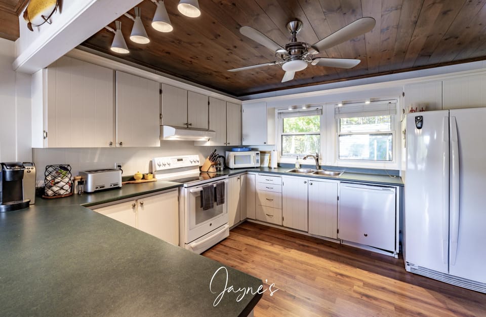 Bright, spacious kitchen with rustic wood ceiling and natural light