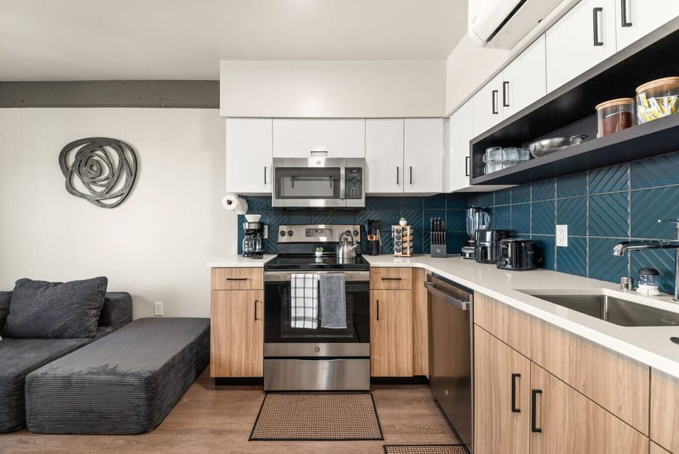 - Fully equipped kitchen with stainless steel appliances   - Coffee maker, microwave, and cookware for every meal   - Modern blue tile backsplash adds a stylish touch