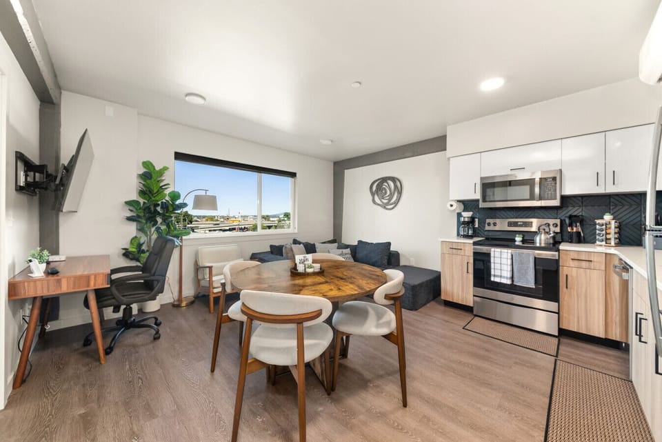 - Bright open-concept living room with natural light and city views   - Fully equipped kitchen with stainless appliances and dining space   - Smart TV, workspace, and modern decor perfect for short stays