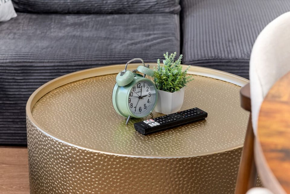- Modern coffee table decor with clock and mini plant   - Cozy living setup blending comfort and aesthetic charm   - Ideal spot for morning coffee or relaxed evening TV time