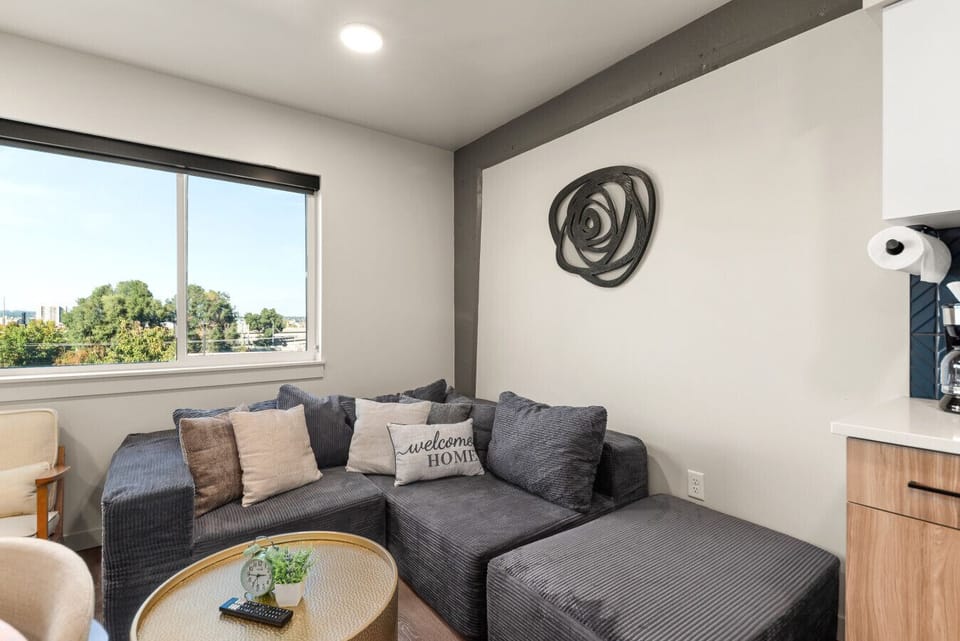 - Stylish lounge corner with plush sectional sofa and decor   - “Welcome Home” comfort meets modern simplicity and city views   - Ideal spot to unwind after exploring nearby attractions
