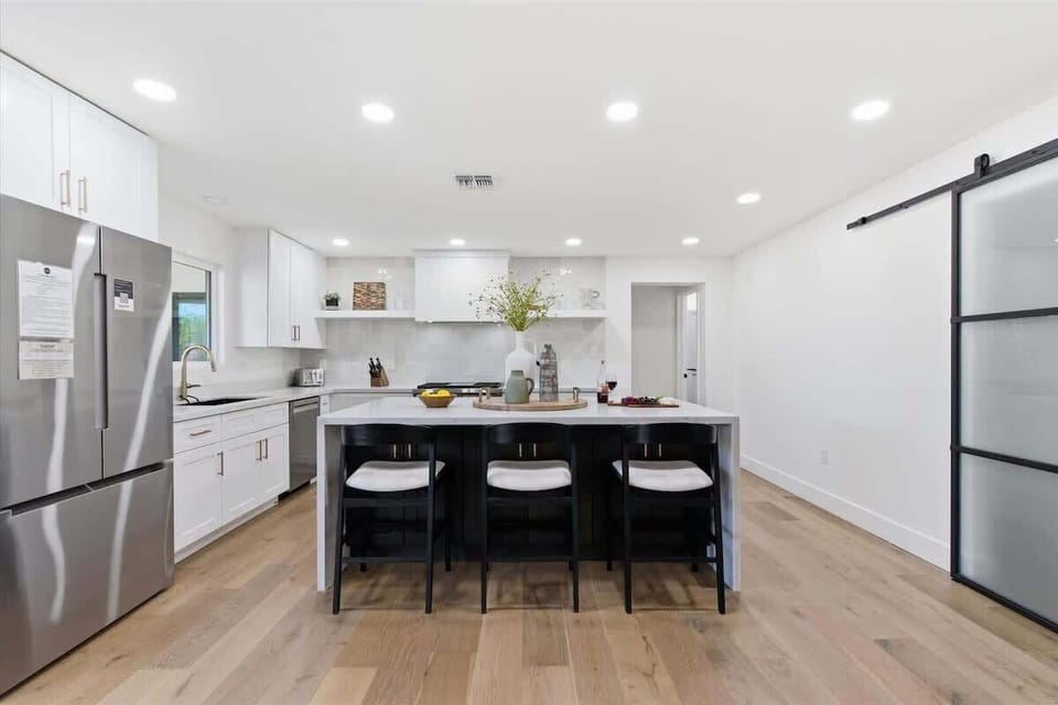 Fully equipped kitchen with stainless steal appliances and a kitchen island with bar seating for 3 guests.