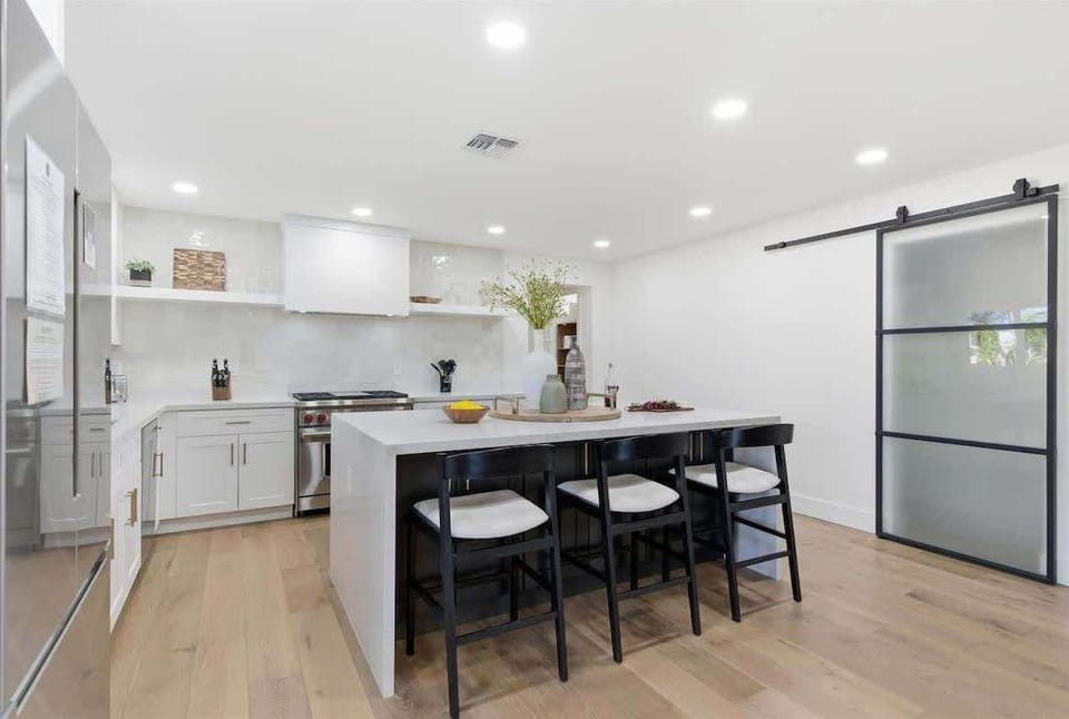 Fully equipped kitchen with stainless steal appliances and a kitchen island with bar seating for 3 guests.