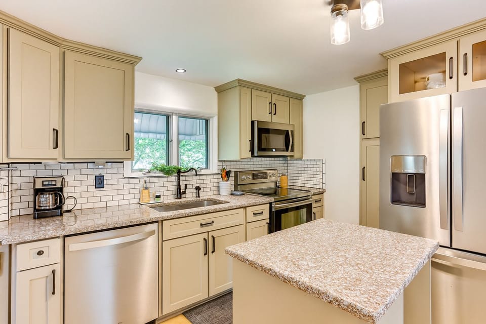 Full kitchen with stainless steel appliances and counter space for cooking.