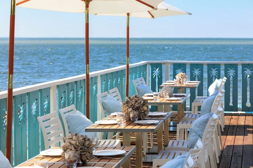 Relax on beachfront loungers facing a glassy, tranquil horizon.