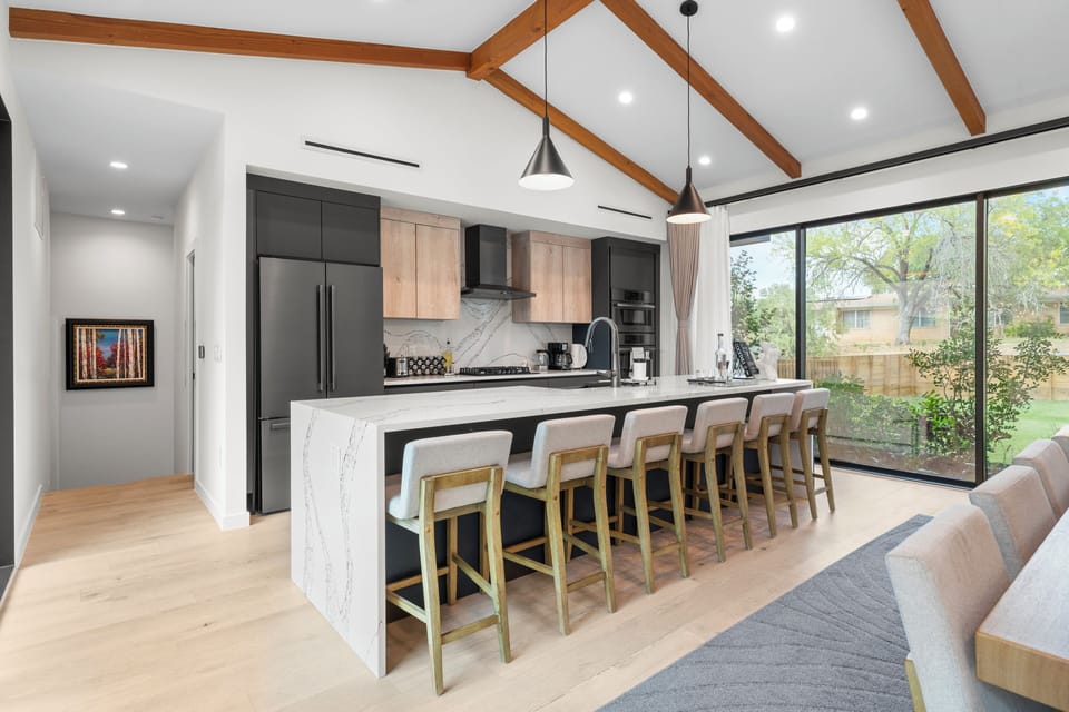 Modern kitchen with island and barstool seating. (Main House)