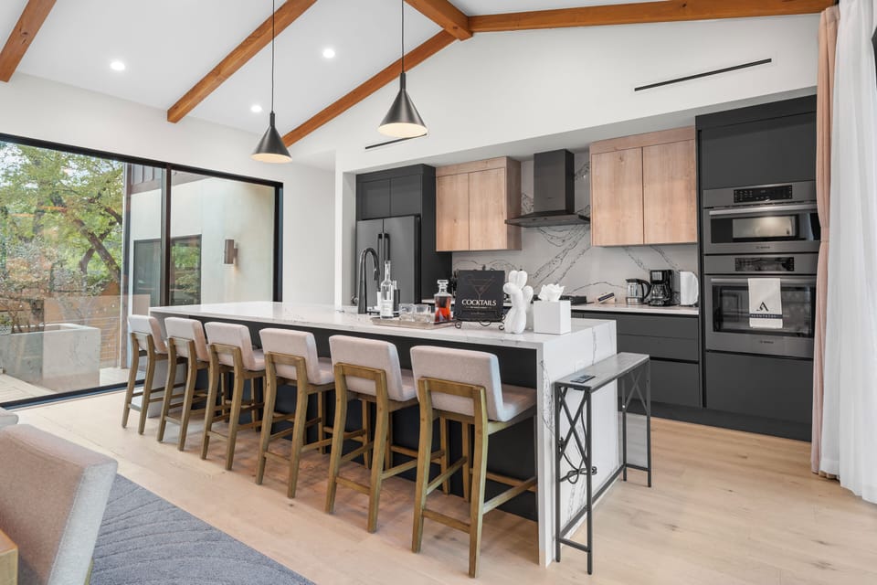 Modern kitchen with island and barstool seating. (Main House)