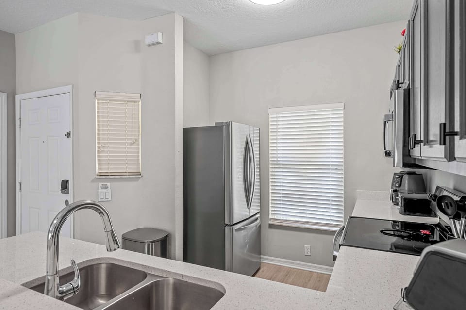Modern kitchen with stainless steel appliances and quartz countertops.