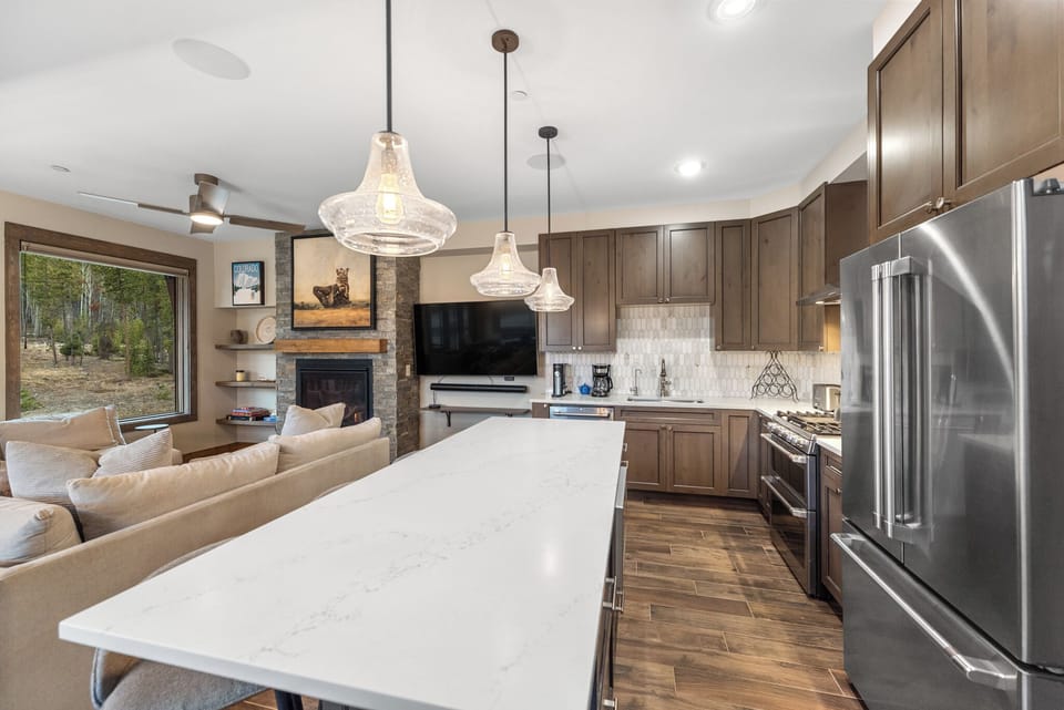 Your gourmet kitchen flows seamlessly into the cozy living area, where granite counters and stainless appliances meet warm wood tones and fireplace charm.