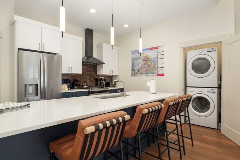 Your modern kitchen features sleek appliances, granite countertops, and a breakfast bar where you can enjoy morning coffee while staying connected to the space.