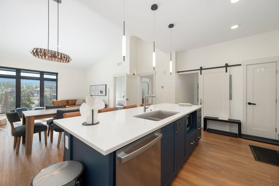 Gather around your sleek kitchen island where culinary adventures begin, with pendant lighting creating intimate ambiance for memorable meals.