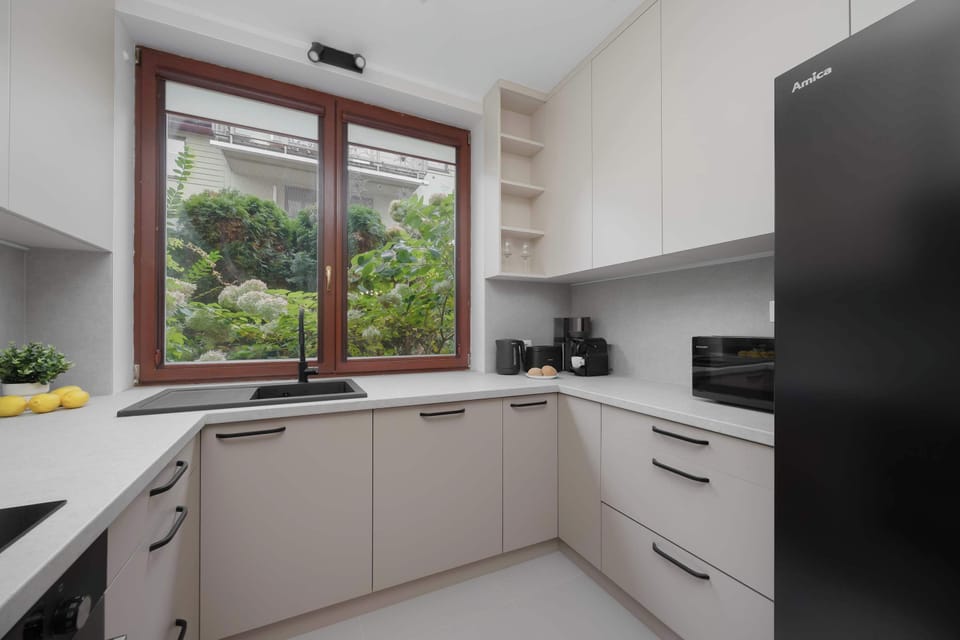 A sleek modern kitchen equipped with white cabinets, built-in appliances, and wooden accents for a warm yet contemporary look.