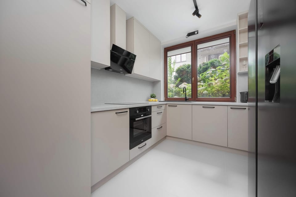 A sleek modern kitchen equipped with white cabinets, built-in appliances, and wooden accents for a warm yet contemporary look.
