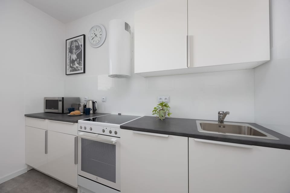 The kitchen's sleek design includes all necessary cookware and utensils.