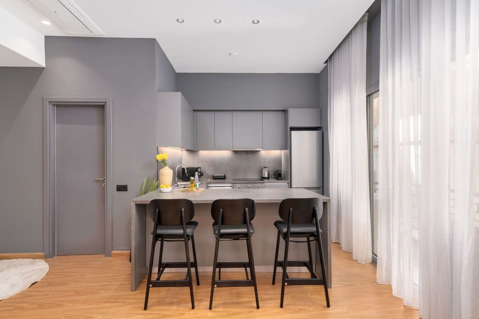 A modern culinary space with soft light and clean geometry — designed for connection, calm, and effortless living.