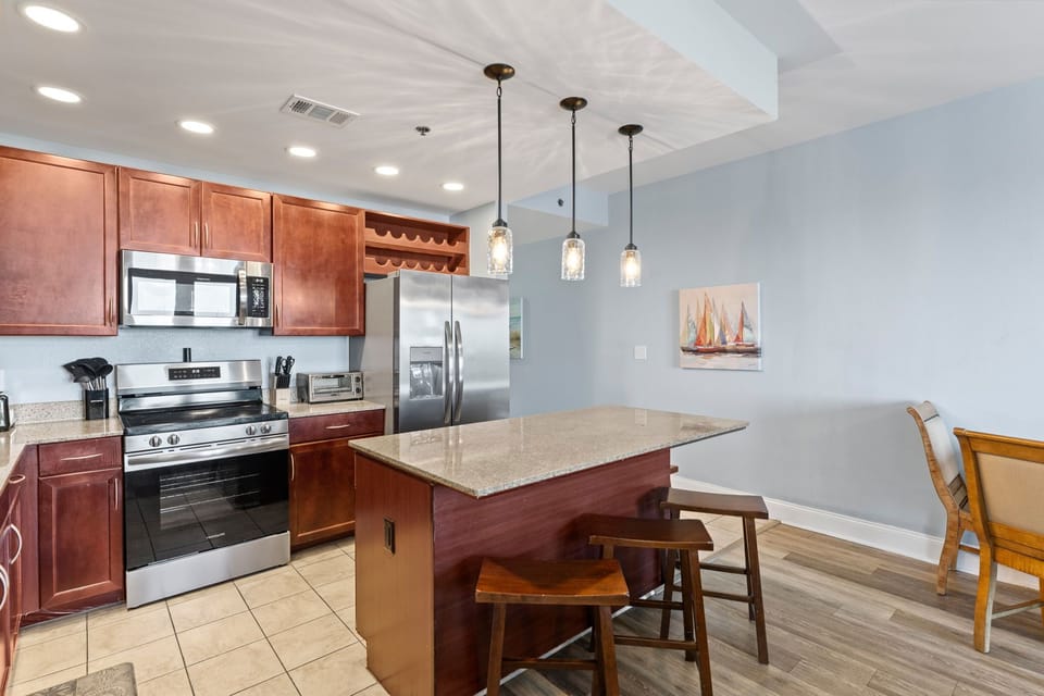 Modern kitchen with stainless steel appliances and a granite island for casual dining.