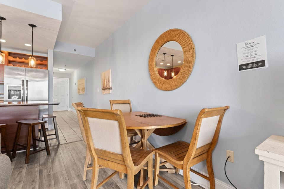 Cozy dining area with natural wood furniture and a round mirror.