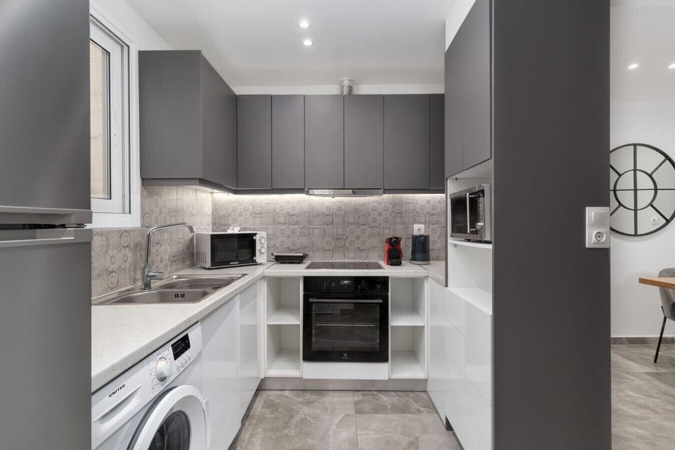 Modern kitchen with oven, washing machine, and espresso maker — designed for extended and short stays alike.