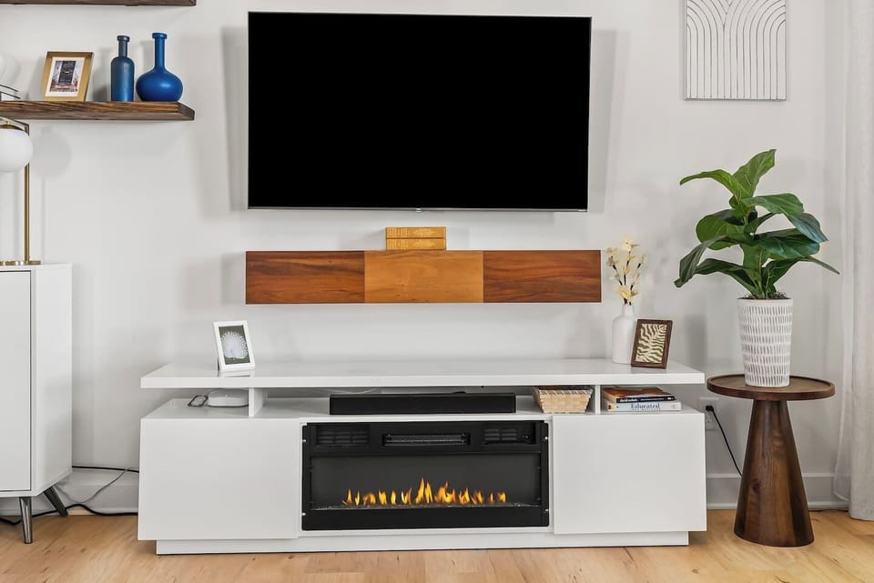 A cozy, contemporary living room with a large flat-screen smart TV mounted on the wall, creating the perfect space for relaxing and entertainment.