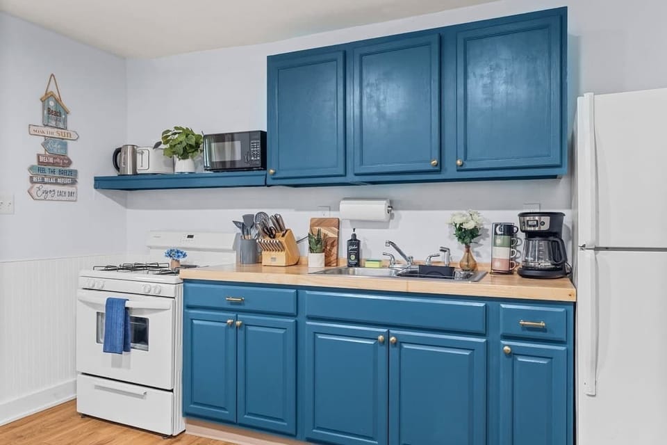 Modern kitchen with blue cabinetry, complete with cookware, utensils, and appliances. Everything you need to prepare your favorite meals.