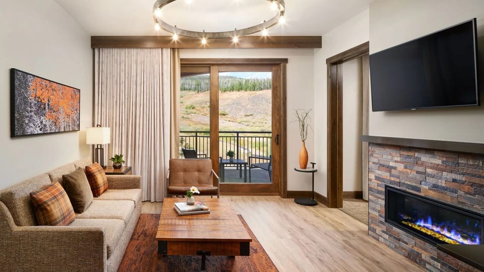 Living room with TV, fireplace, balcony and pull-out queen bed couch