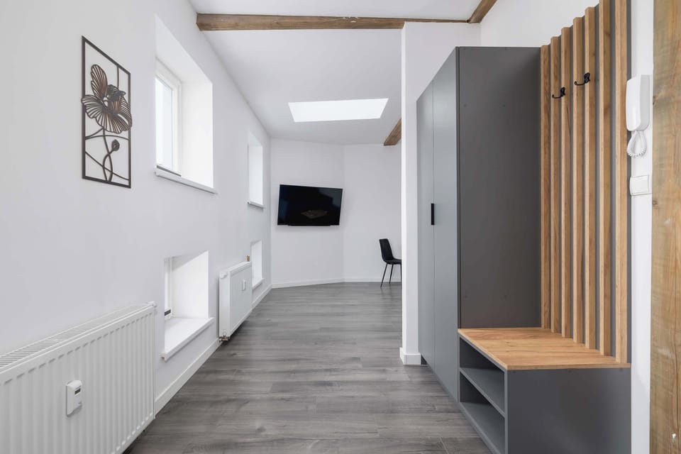 Long view of the corridor leading to the living area. Bright lighting emphasizes the spacious layout.