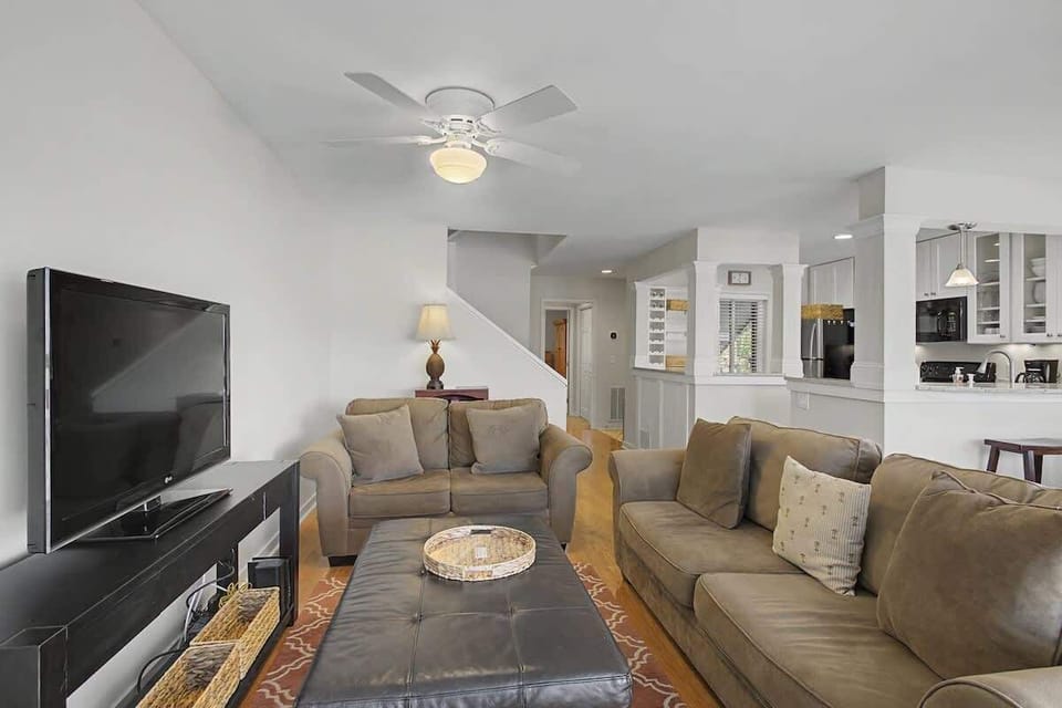 Relax in your spacious living room with plush seating, entertainment center, and open flow to the kitchen.