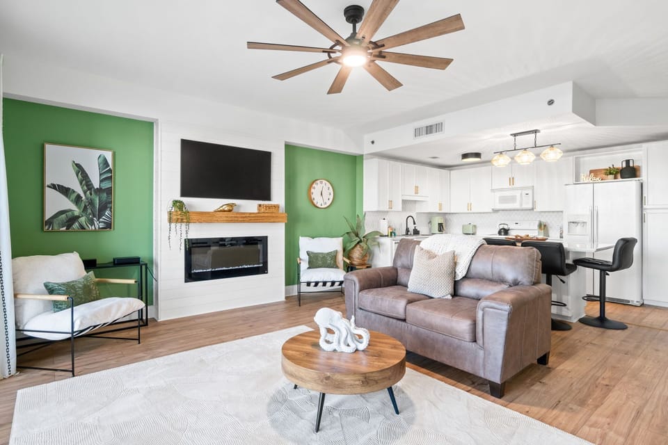 A ceiling fan overhead adds breezy comfort, while the oversized flat-screen TV anchors the room for movie nights or catching the big game.