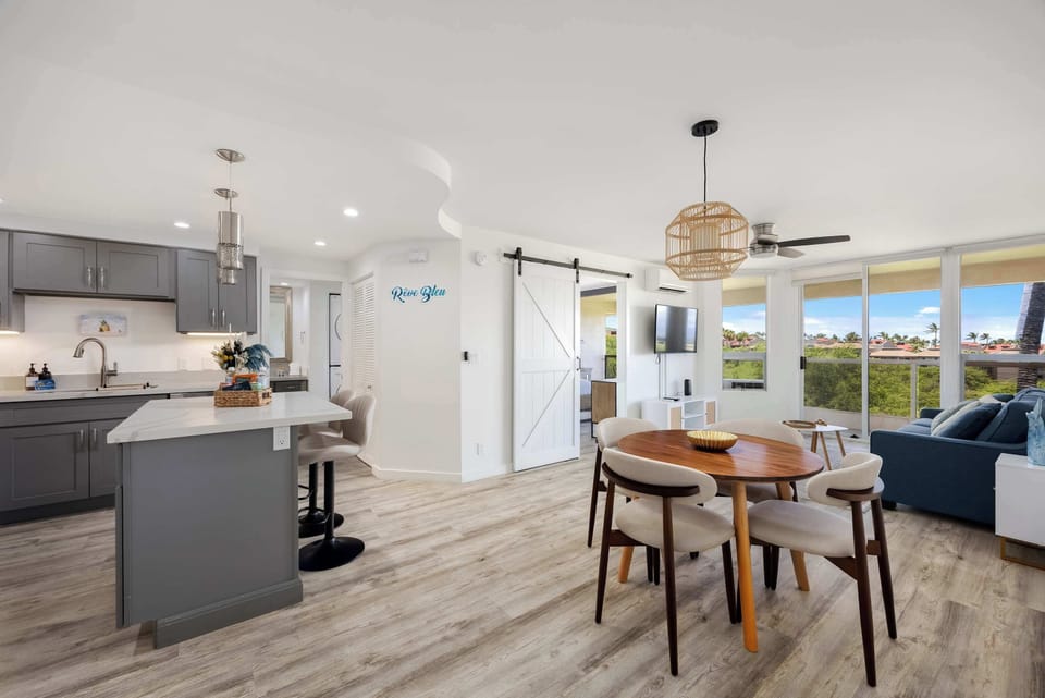 Experience seamless island living in your spacious, open-concept condo featuring a modern kitchen, stylish dining nook, and bright, breezy views.