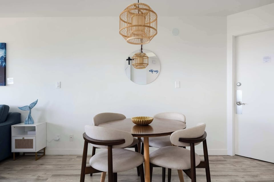 Share meals and conversation in your stylish dining nook, featuring comfortable mid-century seating and a warm woven pendant light.
