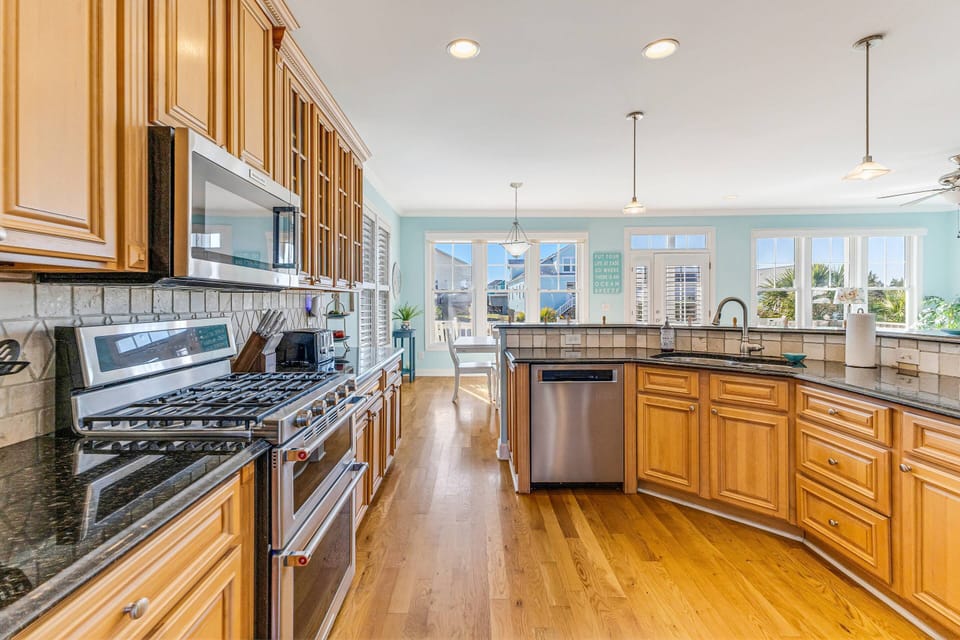 The kitchen is well-equipped with appliances, including an oven with stove, microwave, toaster, and features stylish wooden cabinets and drawers.